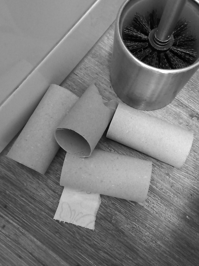 lege toiletrollen op de vloer van de wc naast de wc-borstel